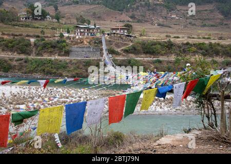 Bhutan, Punakha. Punakha Suspension Bridge, draped in prayer flags, spanning the Tsang Chhu aka Po Chhu river. Longest suspension bridge in Bhutan. Stock Photo