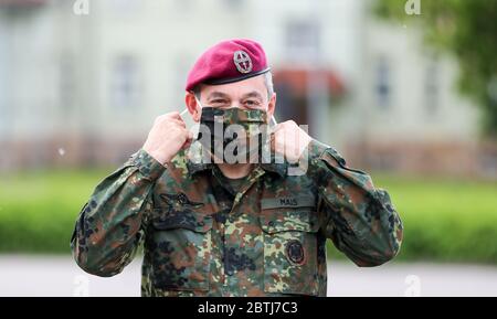 26 May 2020, Saxony, Frankenberg: Lieutenant General Alfons Mais (M), Inspector of the Army, visits Panzergrenadierbrigade 37 during the presentation of the rollout of the Battle Management System and puts on a mouth-and-nose protection. The system has been introduced in the Armed Forces Base since the beginning of April 2020 and in the Army since 11 May 2020. The system forms the backbone of the Bundeswehr's digitalization and enables the deployed units to capture a complex situation picture on the screens in the vehicles. All information on the situation of the own and enemy forces is merged Stock Photo