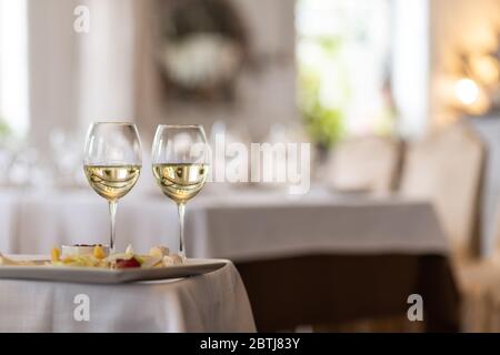 Photo of bottle with pouring champagne in wine glasses on gray background Stock Photo