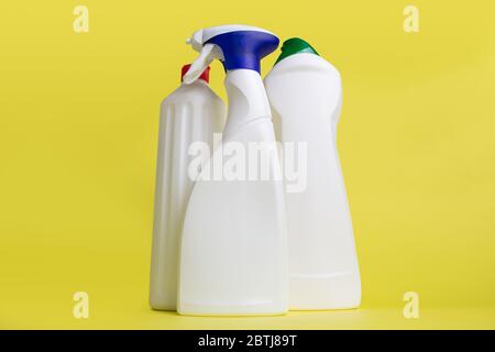 three cans of cleaning products on yellow background Stock Photo