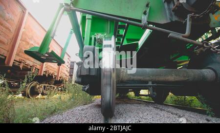 Toned closeup image of massive metal wheels and axle on cargo train car Stock Photo