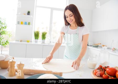 Photo of beautiful cheerful housewife enjoy hobby preparing family recipe dinner forming making dough for pizza quarantine time stay home modern Stock Photo