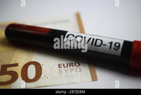 Financial immediate emergency action concept: Close up of isolated 50 Euro paper money bank note with blood sample tube and text covid-19 (focus on wo Stock Photo