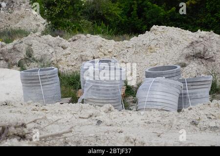 Iron concrete rings. Construction of a sewerage system. Stock Photo