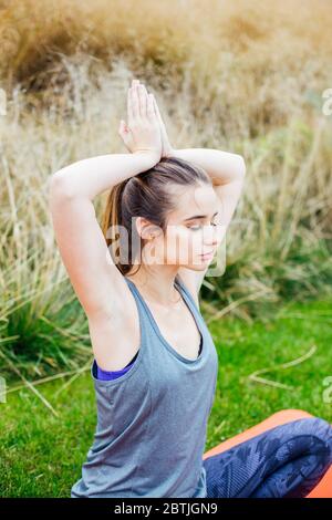 Young woman doing yoga exercise in the park Stock Photo