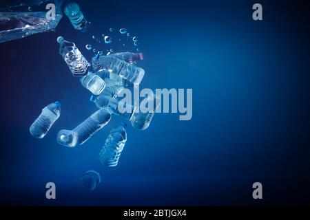 Plastic bottles sinking in to the ocean. Enviromental polution concept. World ocaens day Stock Photo