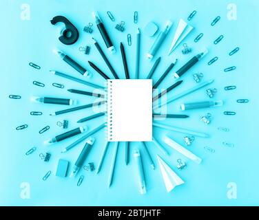 Back to school background with opened notepad and variety of school supplies in trendy aqua color. Flat lay. Close-up. Copy space. Mockup for your des Stock Photo