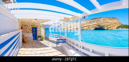 Matala beach with caves on the rocks that were used as a roman cemetery and at the decade of 70's were living hippies from all over the world, Crete, Stock Photo