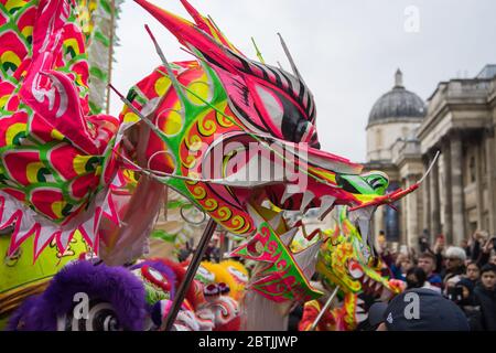 Bright Chinese Dragon head making its way through the crowd. Chinese New Year Celebration Parade. London Stock Photo
