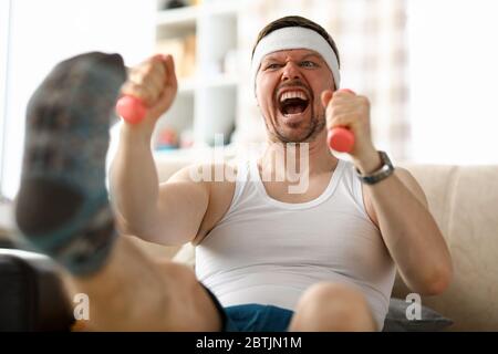 Guy doing exercises with dumbbells in his hands Stock Photo