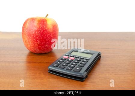 An apple, a calculator, pen, flash drive, notebook, lie on the table. Stock Photo