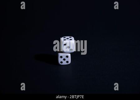 Two dice on black background, Static, horizontal, Two dice on black background, Static, horizontal, one on top of the other Stock Photo