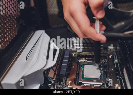Male hands wear gloves, use thermal grease on the processor Stock Photo