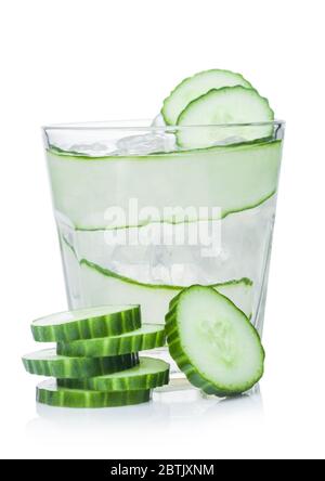 Fresh cold cucumber water with ice cubes and cucumber slices on white background. Healthy and refreshing organic drink. Stock Photo