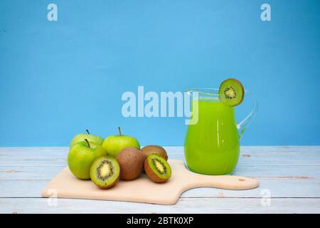 Apples and kiwi on cutting board with green juice Stock Photo