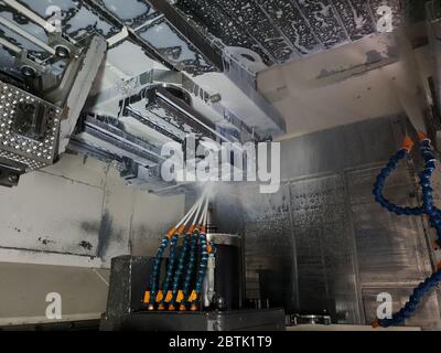 Metalworking CNC Milling Machine Produces Metal Detail on Factory. Coolant and lubrication. Operation high-tech machine lathe metal processing Stock Photo
