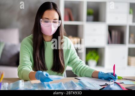 Photo of asian lady working family business organizing orders facial flu cold medical masks global spreading counting customers preparing packs for Stock Photo