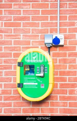 Defibrillator on a brick wall, UK. Stock Photo