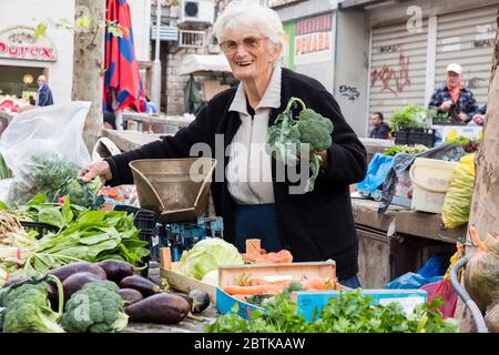 Older female fruit & vegetable vendor smiling at Split's Green Market, just outside of the Diocletian's Palace, Old Town, Split, Croatia