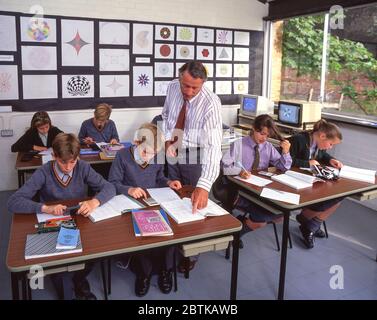 Maths teacher in a secondary school classroom with pupils. England. UK ...
