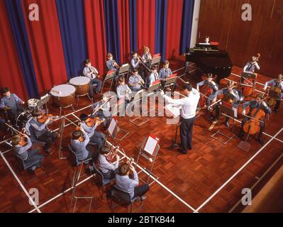 Boys playing violins and flutes in school orchestra, Surrey, England, United Kingdom Stock Photo