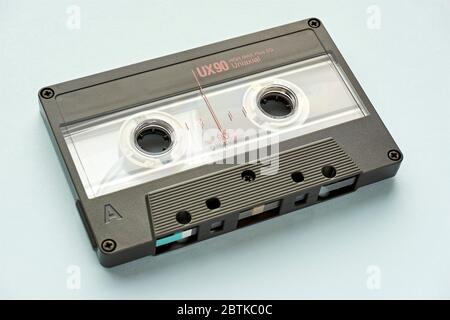 Closeup of plastic audio tape cassette on light blue background. Vintage background. Stock Photo