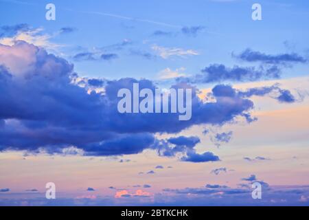 Dramatic sunset sky with bright multi-colored cumulus clouds with dramatic light, natural pastel colours Stock Photo