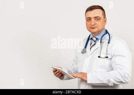 Portrait of a male doctor using a digital tablet. Doctor using a tablet and checks the analysis on a virtual interface. Medicine. Medical science and biotechnology. Stock Photo