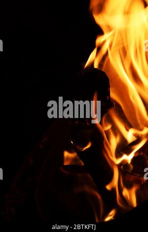 A fire pit burning wood on a cold night, flames dancing around making art. Images captured close up in vivid color for reprint or backgrounds. Stock Photo