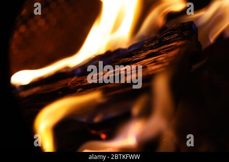 A fire pit burning wood on a cold night, flames dancing around making art. Images captured close up in vivid color for reprint or backgrounds. Stock Photo