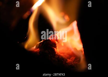 A fire pit burning wood on a cold night, flames dancing around making art. Images captured close up in vivid color for reprint or backgrounds. Stock Photo