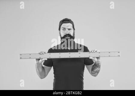 Shop assistant. Perfect size. Bearded man with big measuring instrument. Measuring with ruler. Size measurement. Measuring length. Size clothes. Student study stem disciplines. Ruler tool equipment. Stock Photo