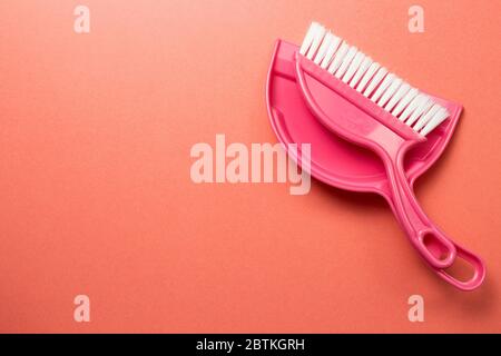 Pink broom and dustpan isolated on pink background. top view Stock Photo
