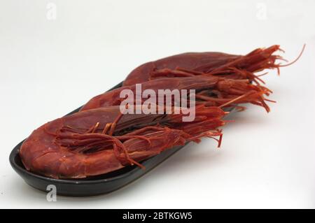 A plate with three prawns known as carabineros (Aristaeopsis edwardsiana) on a neutral white background Stock Photo