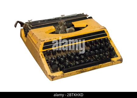 Rusty old vintage yellow typewriter isolated on white background, work with clipping path. Stock Photo