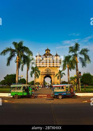 Auto rickshaw in front of the Patuxai Monument in Vientiane Laos Stock Photo