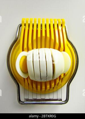Hard-Boiled Egg in A Yellow Egg Slicer Stock Photo