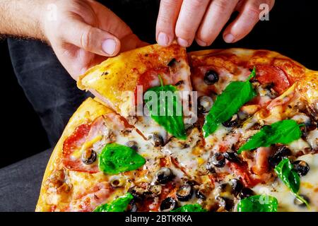 Delicious Italian fresh hot mix baked pizza with fresh ingredients tomatoes, mozzarella cheese, olives, corn and basil. Stock Photo