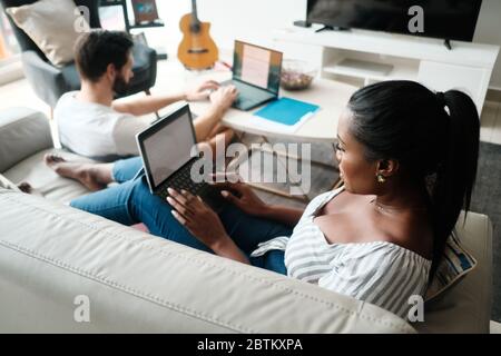Couple Working And Playing With Laptop Computer At Home Stock Photo