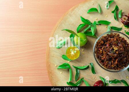 Spicy Chili paste with peppers and lime on wood bacground Stock Photo