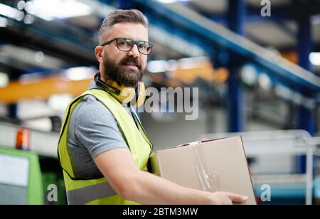 Man worker working in industrial factory or warehouse. Stock Photo