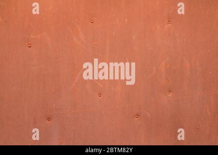 The wall is red orange with scratches and scuffs. Painted iron sheet nailed. The background for text and design. Image for the backdrop and wallpaper. Stock Photo