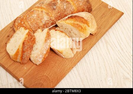 French loafs sliced into pieces on a wooden board Stock Photo