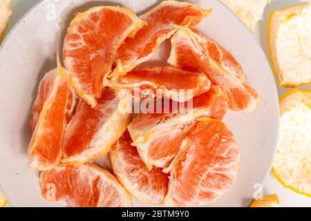 grapefruit slices on a plate. bright red-orange slices of fruit Stock Photo