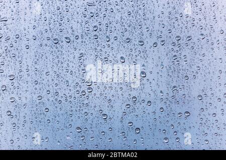 Blue water drops on colored window background. Raindrop on the window vintage background Stock Photo