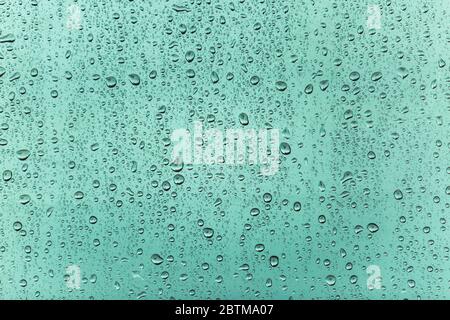 Blue water drops on colored window background. Raindrop on the window vintage background Stock Photo