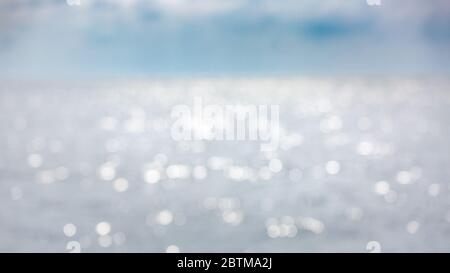 Background of blurred sunset beach and sea waves with bokeh lights. Artistic ocean blur Stock Photo