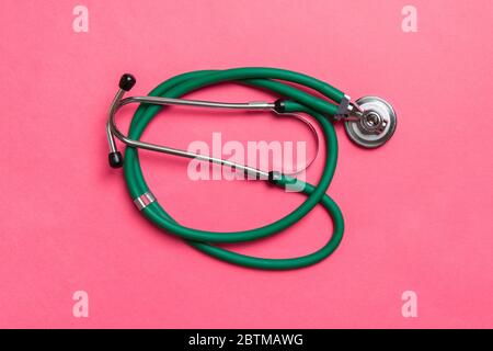 Top view of green stethoscope on colorful background. Medical diagnosis tool concept. Stock Photo