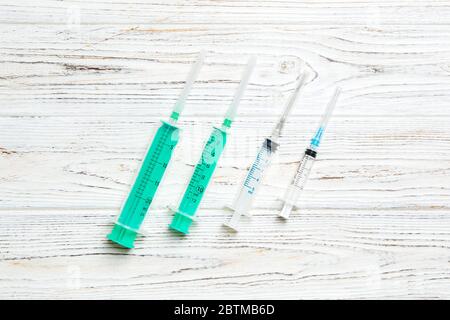 Top view of syringes of different sizes on wooden background. Medical equipment for injection concept with copy space. Stock Photo