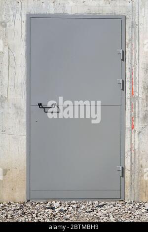 Gray concrete new  wall and  armored  steel  door.  Sunny day outdoor shot Stock Photo
